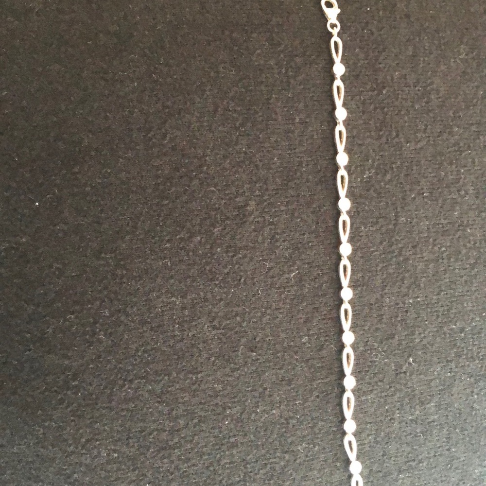 Silver bracket with diamond color stones